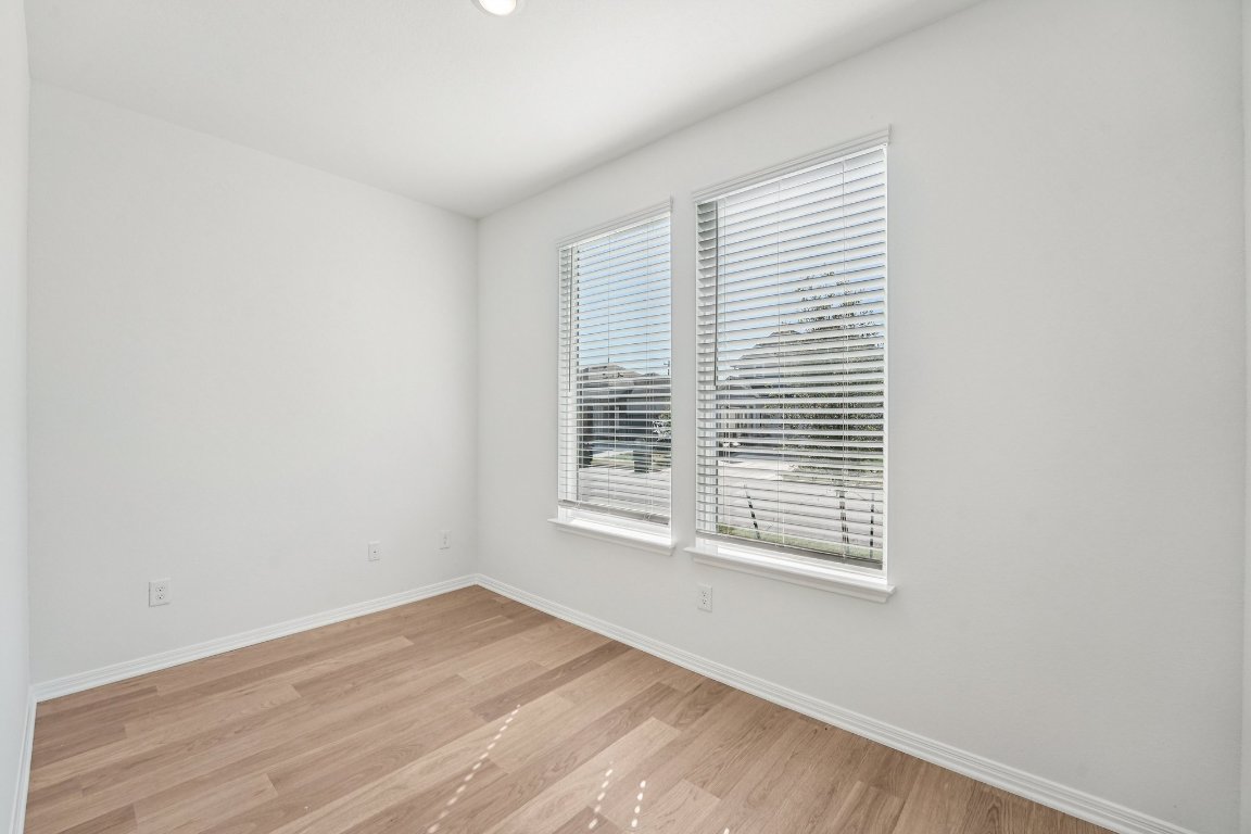 6309 Marsh Lane Buda, TX 78610 - Photo 13 of 39 a view of an empty room with wooden floor and a window