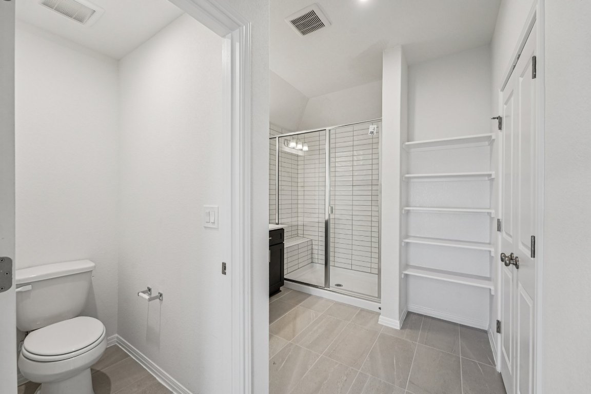 6309 Marsh Lane Buda, TX 78610 - Photo 23 of 39 a bathroom with a toilet and a shower