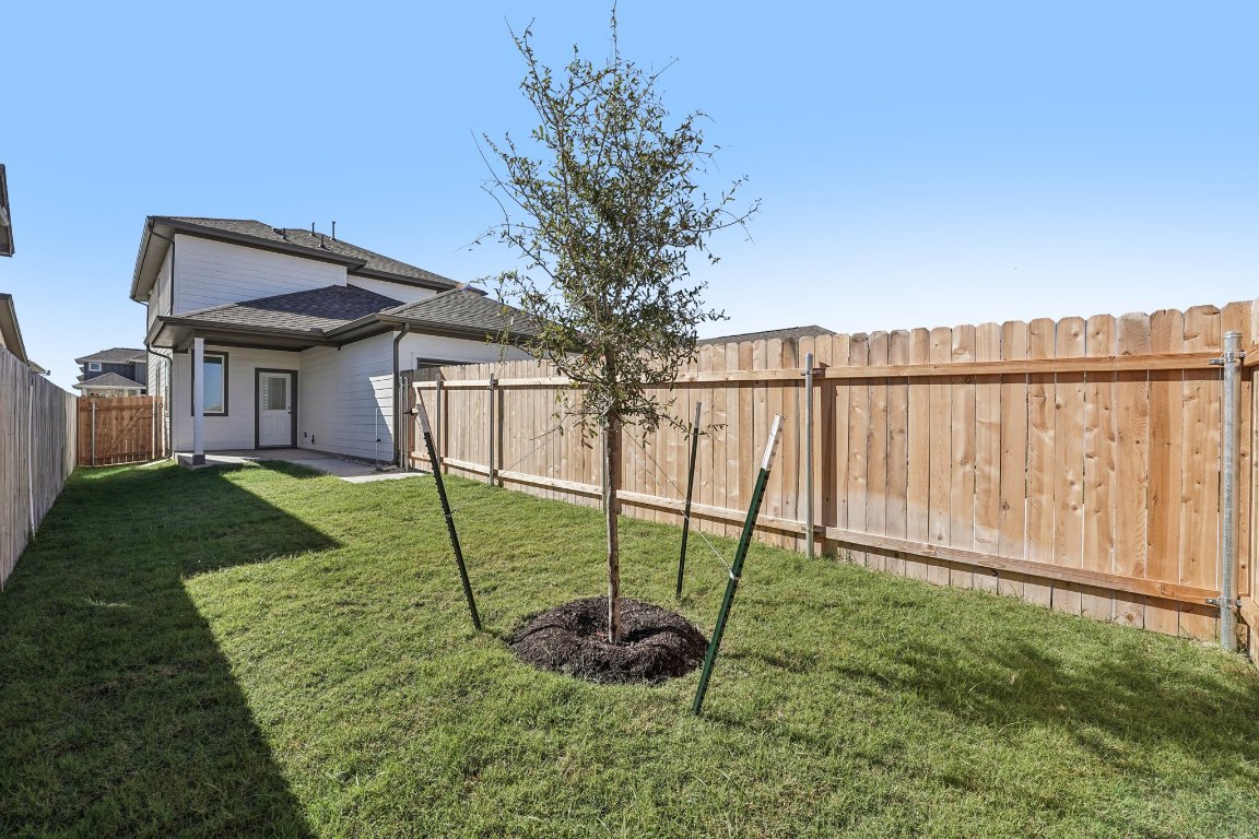 6309 Marsh Lane Buda, TX 78610 - Photo 29 of 39 a view of a house with backyard and a garden