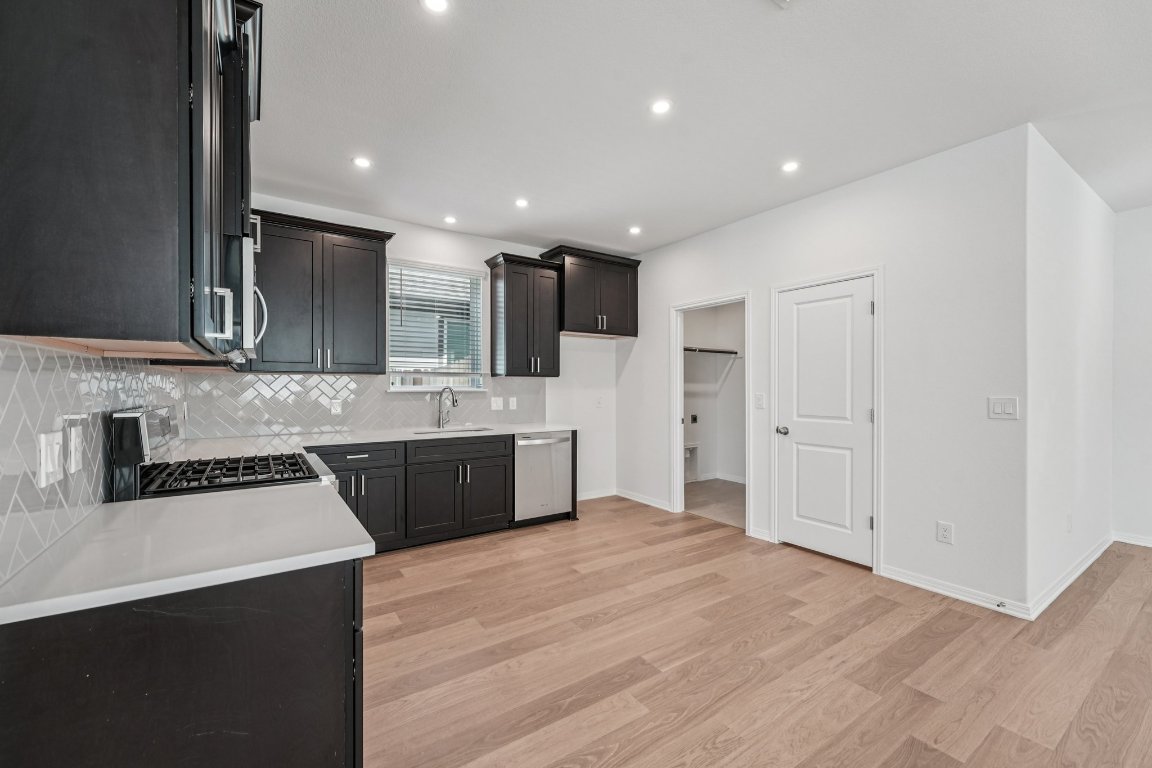 6309 Marsh Lane Buda, TX 78610 - Photo 5 of 39 a large kitchen with stainless steel appliances granite countertop a sink a stove a refrigerator and cabinets