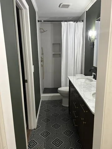 a bathroom with a granite countertop sink double and mirror