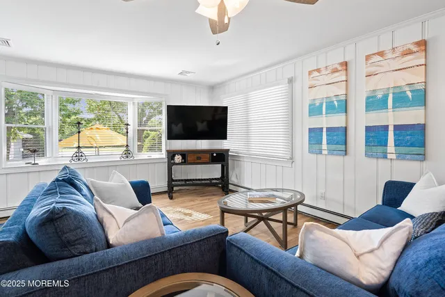 a living room with furniture a flat screen tv and a large window
