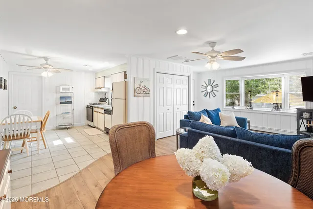 a kitchen with stainless steel appliances granite countertop a refrigerator a stove a sink dishwasher a dining table and chairs with wooden floor