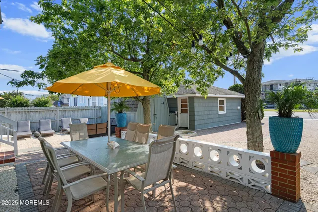 a view of a patio with table and chairs potted plants and a large tree