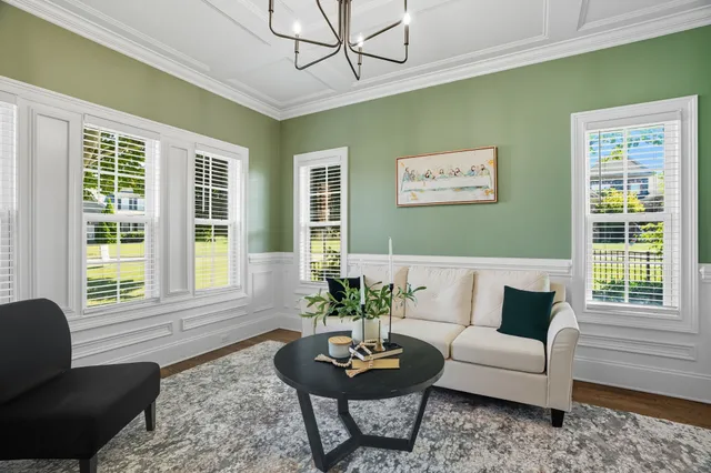 a kitchen with stainless steel appliances granite countertop a dining table chairs refrigerator and window