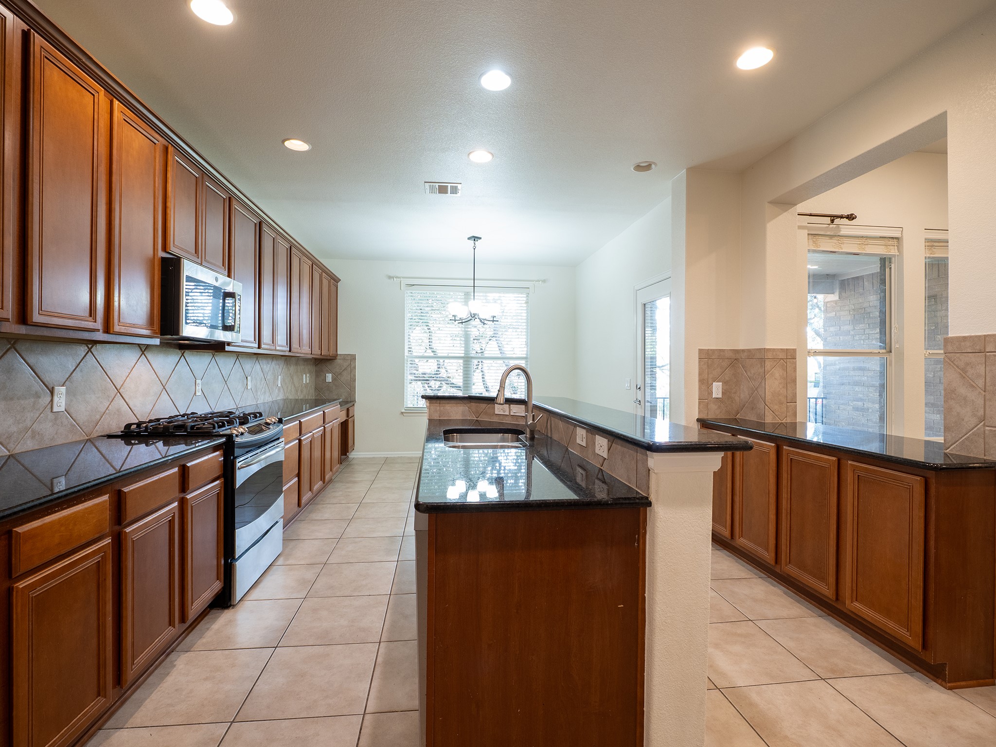 572 Big Meadow Road Austin, TX 78737 - Photo 6 of 32 A well-appointed kitchen showcasing rich wood cabinetry and ample counter space.