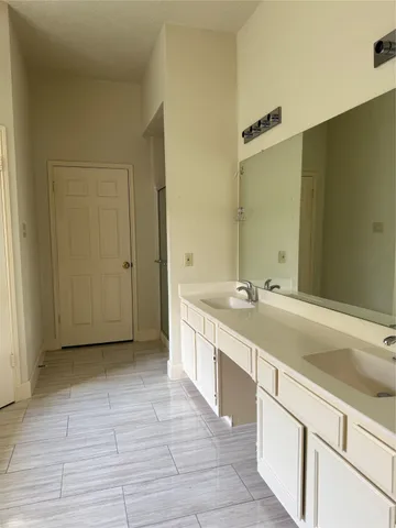 a spacious bathroom with a granite countertop sink and a mirror