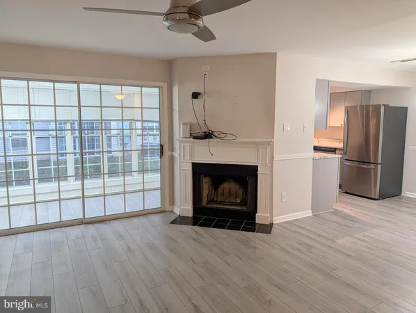 a view of a livingroom with a fireplace wooden floor and window
