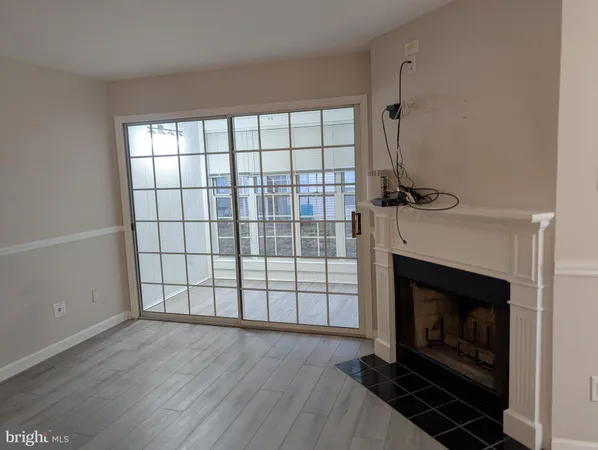 a view of an empty room with a fireplace and a window