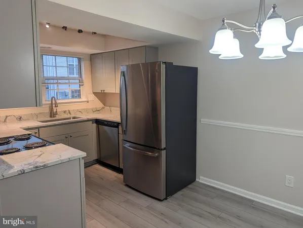 a kitchen with a refrigerator sink and cabinets