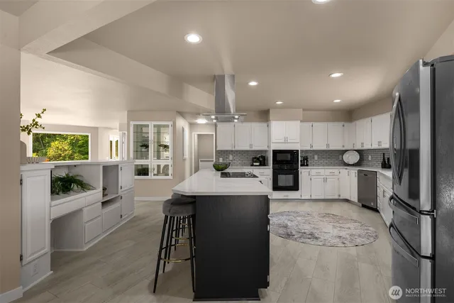 a large kitchen with kitchen island a sink appliances and cabinets