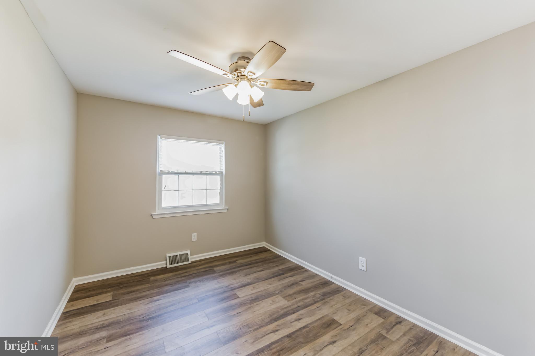357 Saybrook Lane, Unit 158 Wallingford, PA 19086 - Photo 11 of 18 an empty room with wooden floor fan and windows