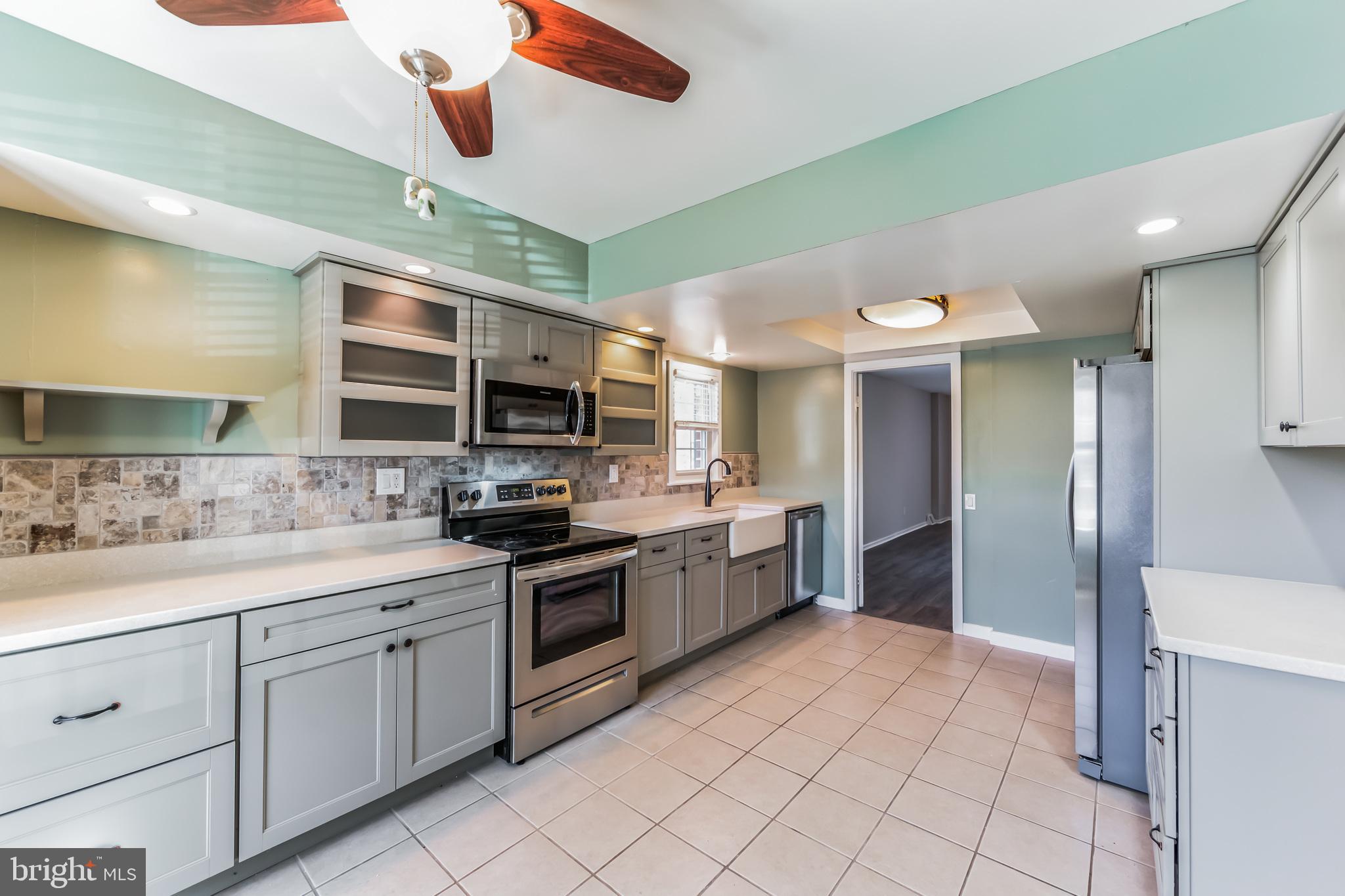 357 Saybrook Lane, Unit 158 Wallingford, PA 19086 - Photo 6 of 18 a kitchen with stainless steel appliances granite countertop a refrigerator and a sink