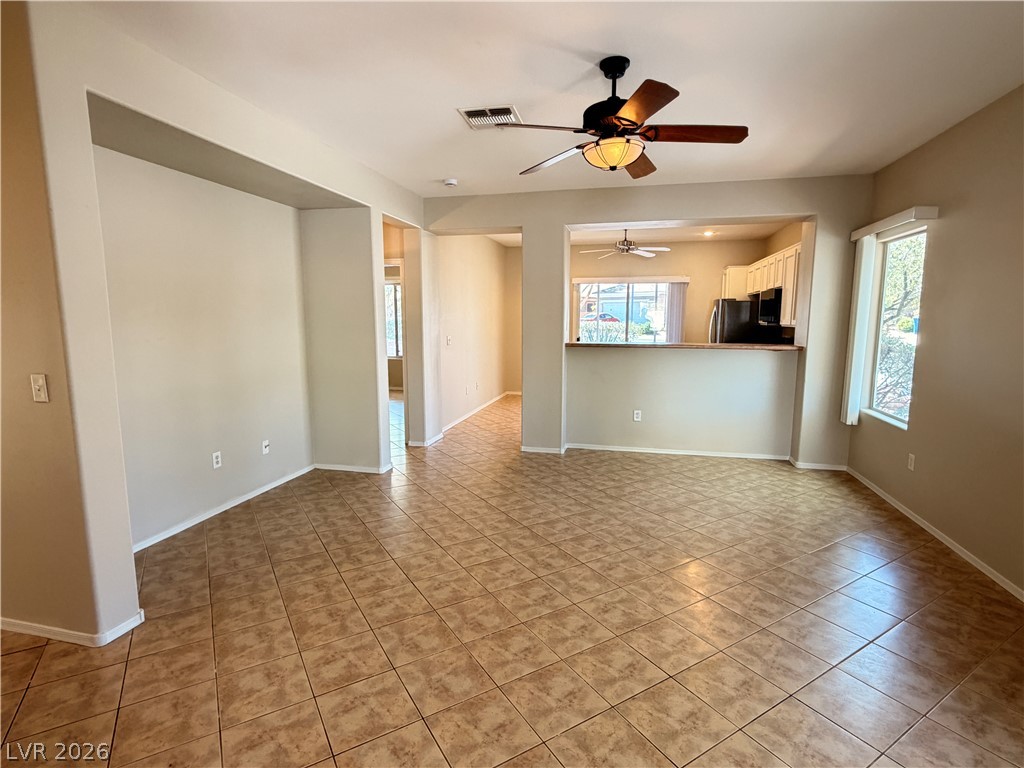 2523 Romanza Road Henderson, NV 89052 - Photo 24 of 24 An open floorplan living area flows seamlessly into the kitchen, featuring tiled flooring and a functional breakfast bar.