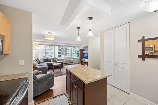 a kitchen with granite countertop white cabinets and stainless steel appliances