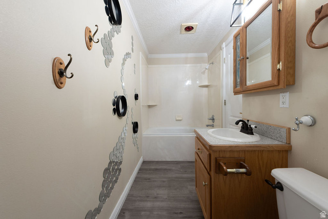 875 East 1300th Street North Mapleton, UT 84664 - Photo 45 of 65 Bathroom with a textured ceiling, shower combination, vanity, dark wood-type flooring, and crown molding