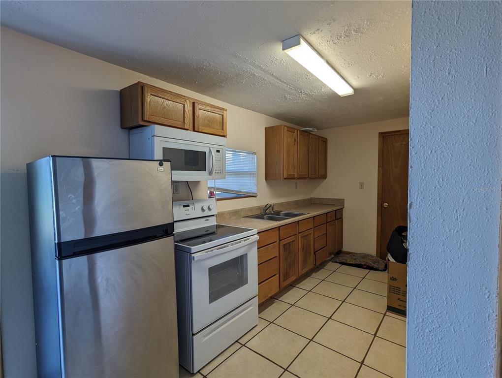 16070 Carlton Lake Road Wimauma, FL 33598 - Photo 5 of 10 a kitchen with stainless steel appliances granite countertop a refrigerator sink and stove