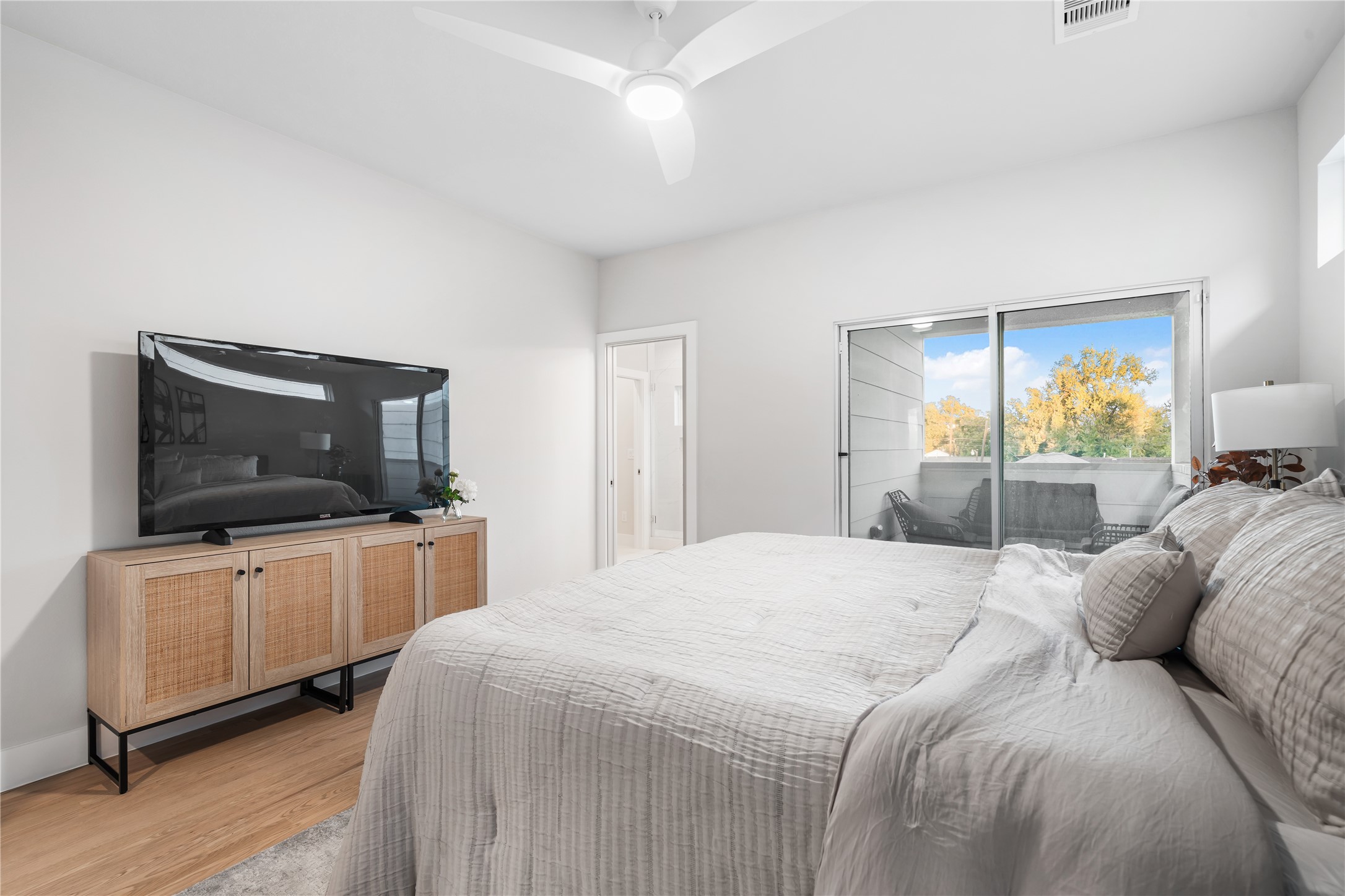 1912 Erastus Street Houston, TX 77020 - Photo 17 of 29 Equipped with a ceiling fan, the primary bedroom features large sliding glass doors that open to your own private covered balcony. The ensuite bath awaits just beyond for added convenience.