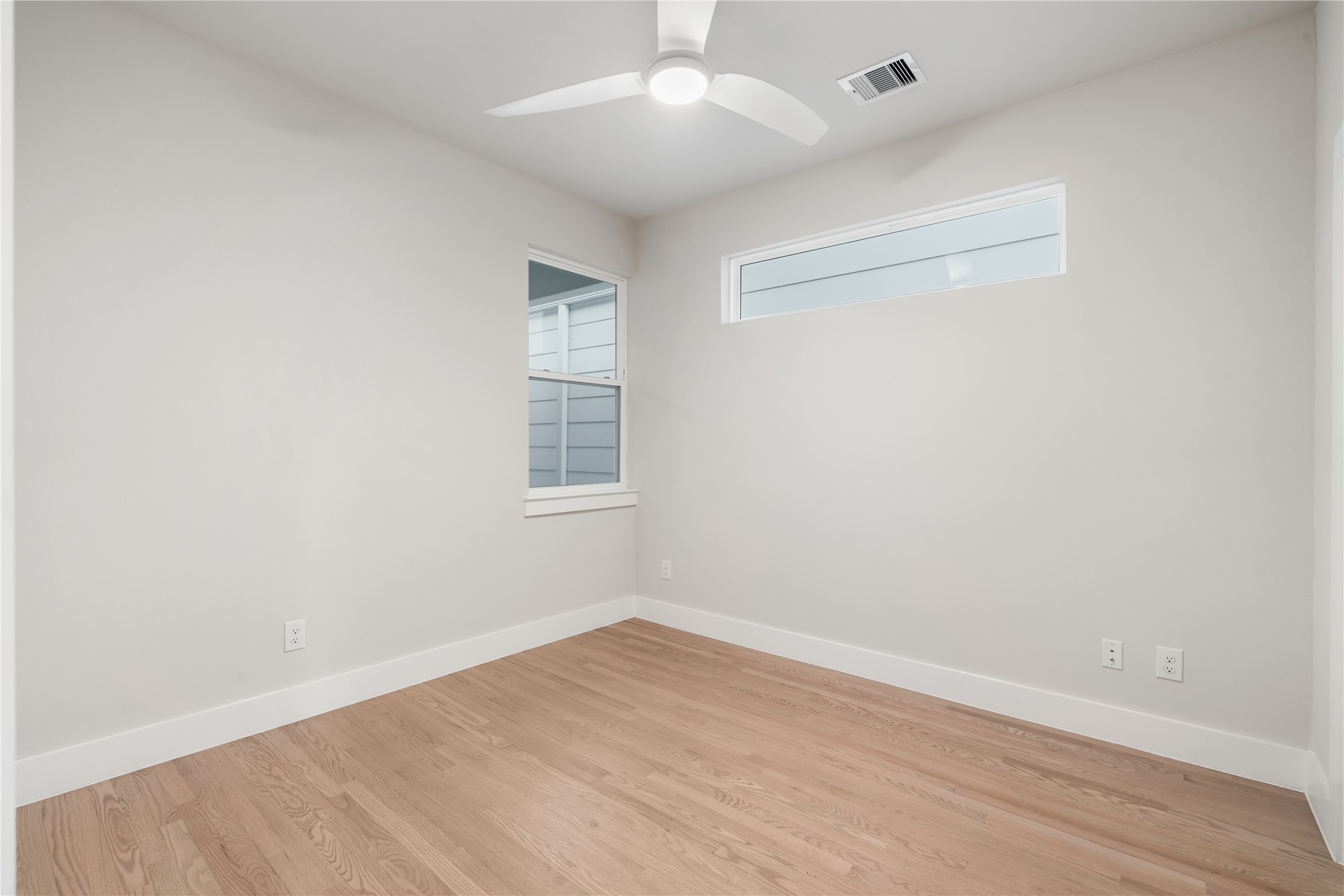 1912 Erastus Street Houston, TX 77020 - Photo 25 of 29 Another secondary bedroom featuring a clerestory window, ceiling fan, and additional window that fills the room with soft, natural light, perfect for a guest room, nursery, or home office.