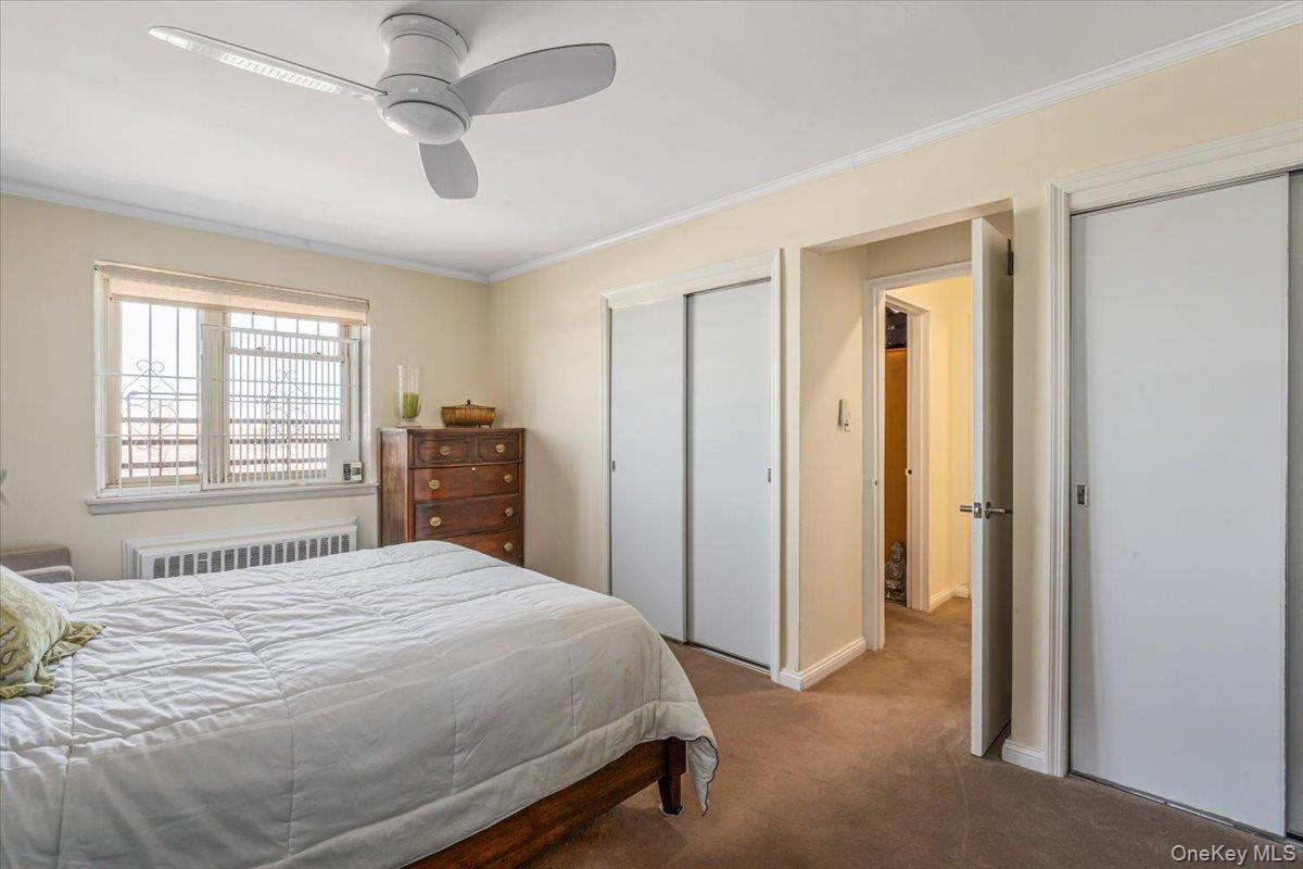 144-60 Gravett Road, Unit 6F Queens, NY 11367 - Photo 14 of 20 a bedroom with a large bed and a chandelier
