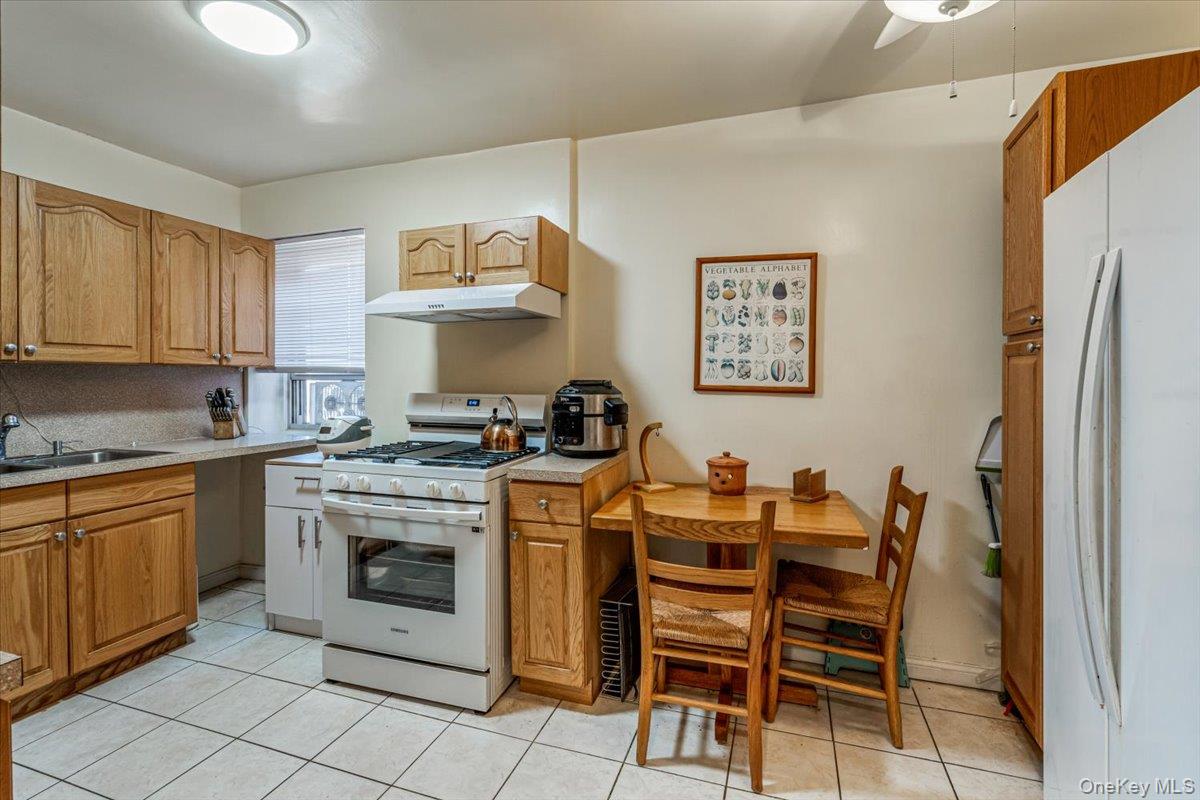 144-60 Gravett Road, Unit 6F Queens, NY 11367 - Photo 16 of 20 a kitchen with stainless steel appliances granite countertop a stove a sink and a refrigerator