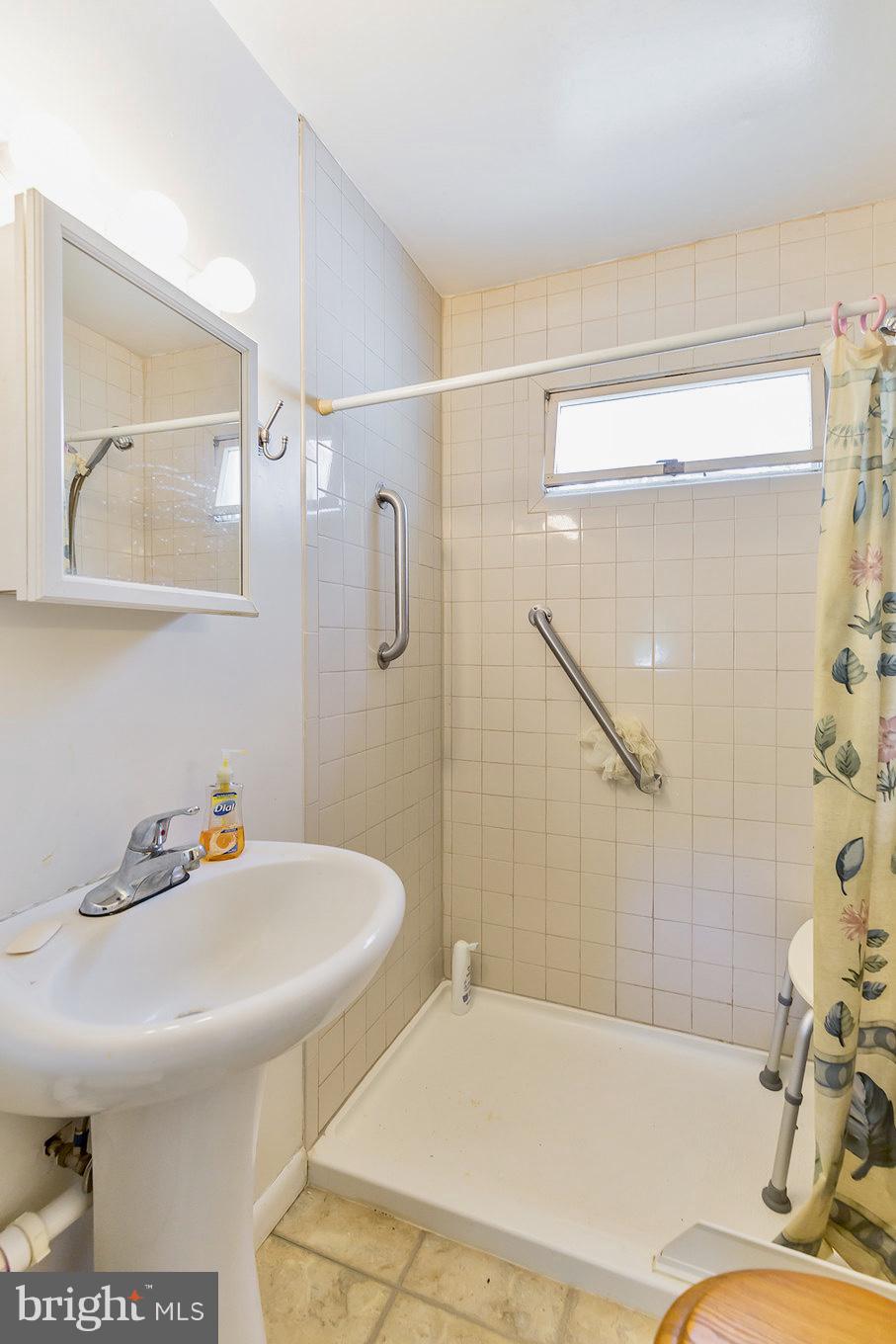 2730 Solomons Island Road Huntingtown, MD 20639 - Photo 17 of 22 a bathroom with a sink and mirror with bathtub