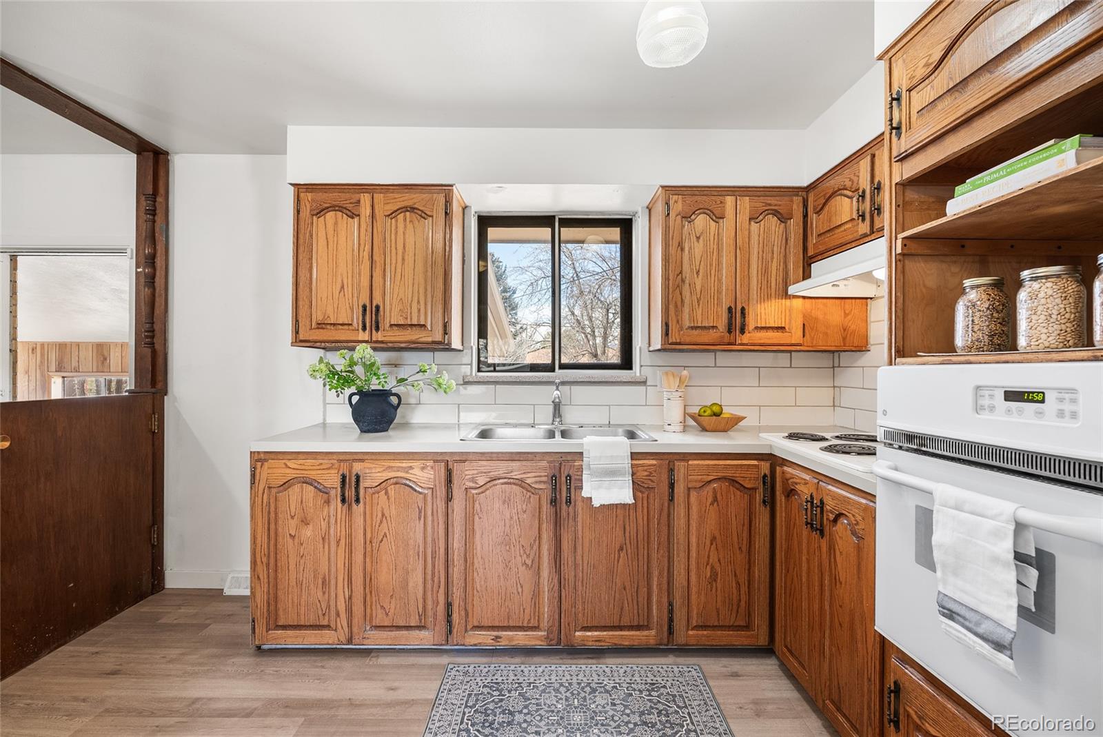 4585 Garland Street Wheat Ridge, CO 80033 - Photo 11 of 35 a kitchen with a sink cabinets and window
