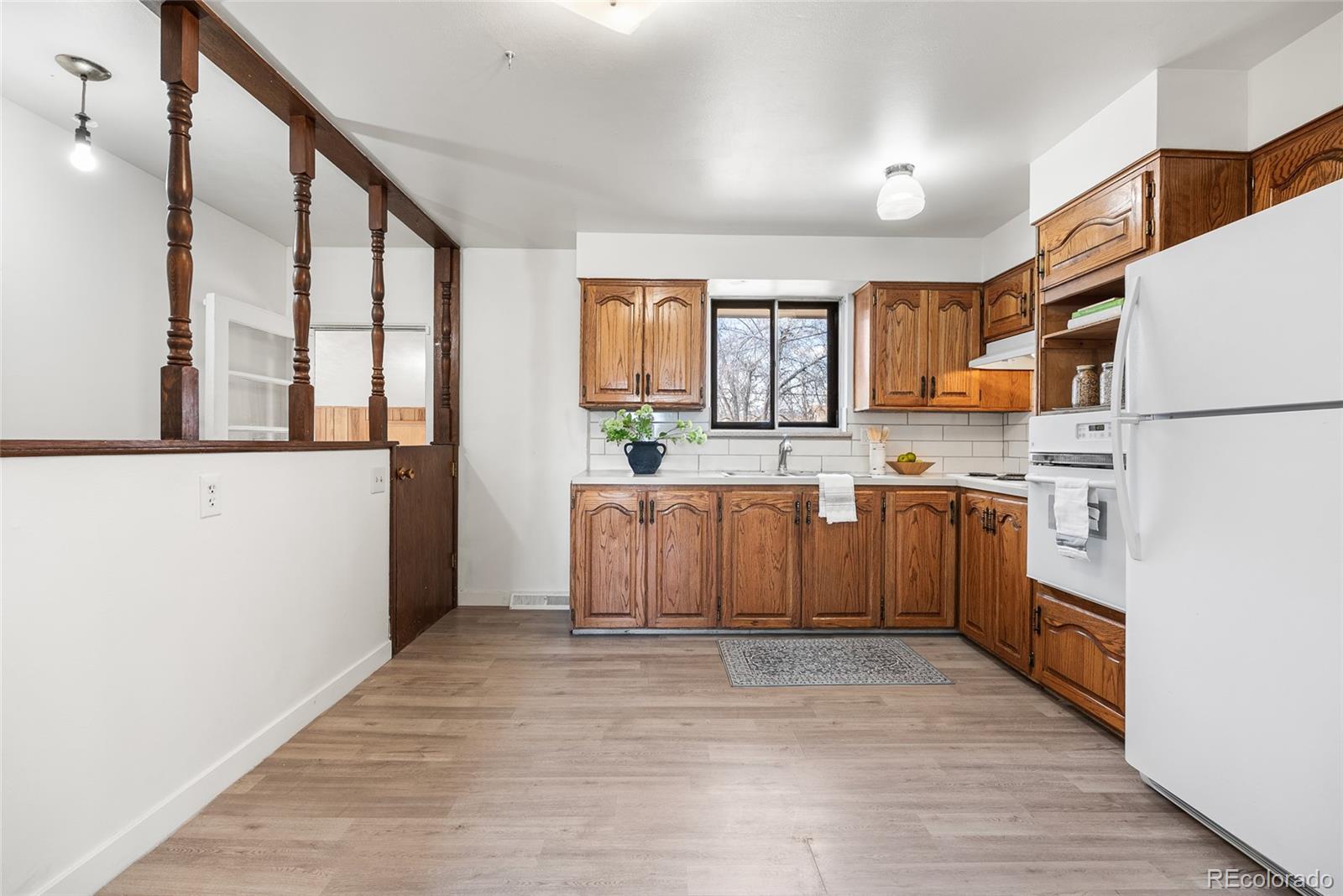4585 Garland Street Wheat Ridge, CO 80033 - Photo 13 of 35 a kitchen with stainless steel appliances granite countertop a stove a sink dishwasher a refrigerator and a cabinets with wooden floor