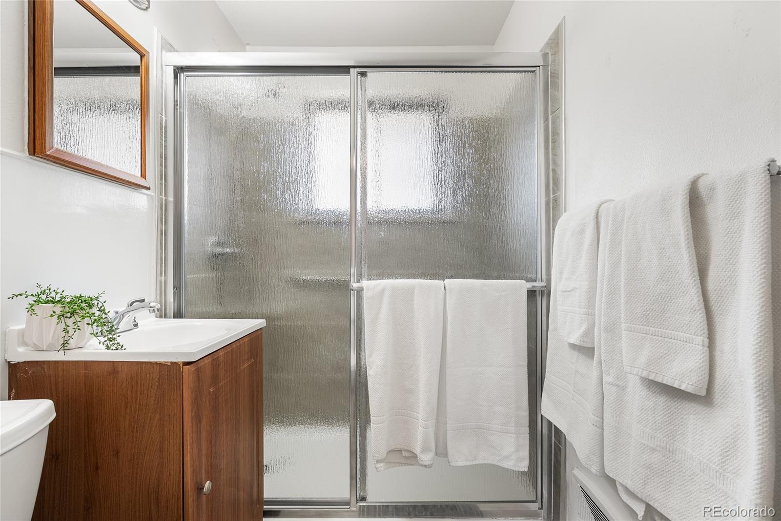 4585 Garland Street Wheat Ridge, CO 80033 - Photo 16 of 35 a bathroom with a sink and mirror with bathtub