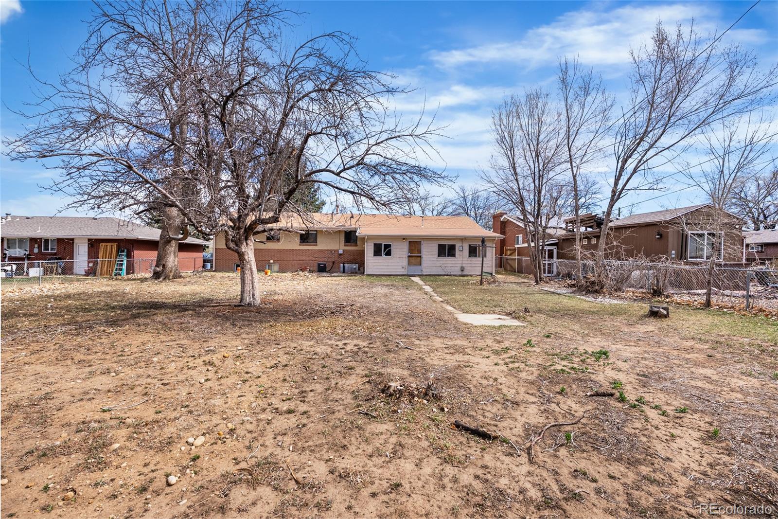 4585 Garland Street Wheat Ridge, CO 80033 - Photo 27 of 35 a front view of a house with a yard covered in snow