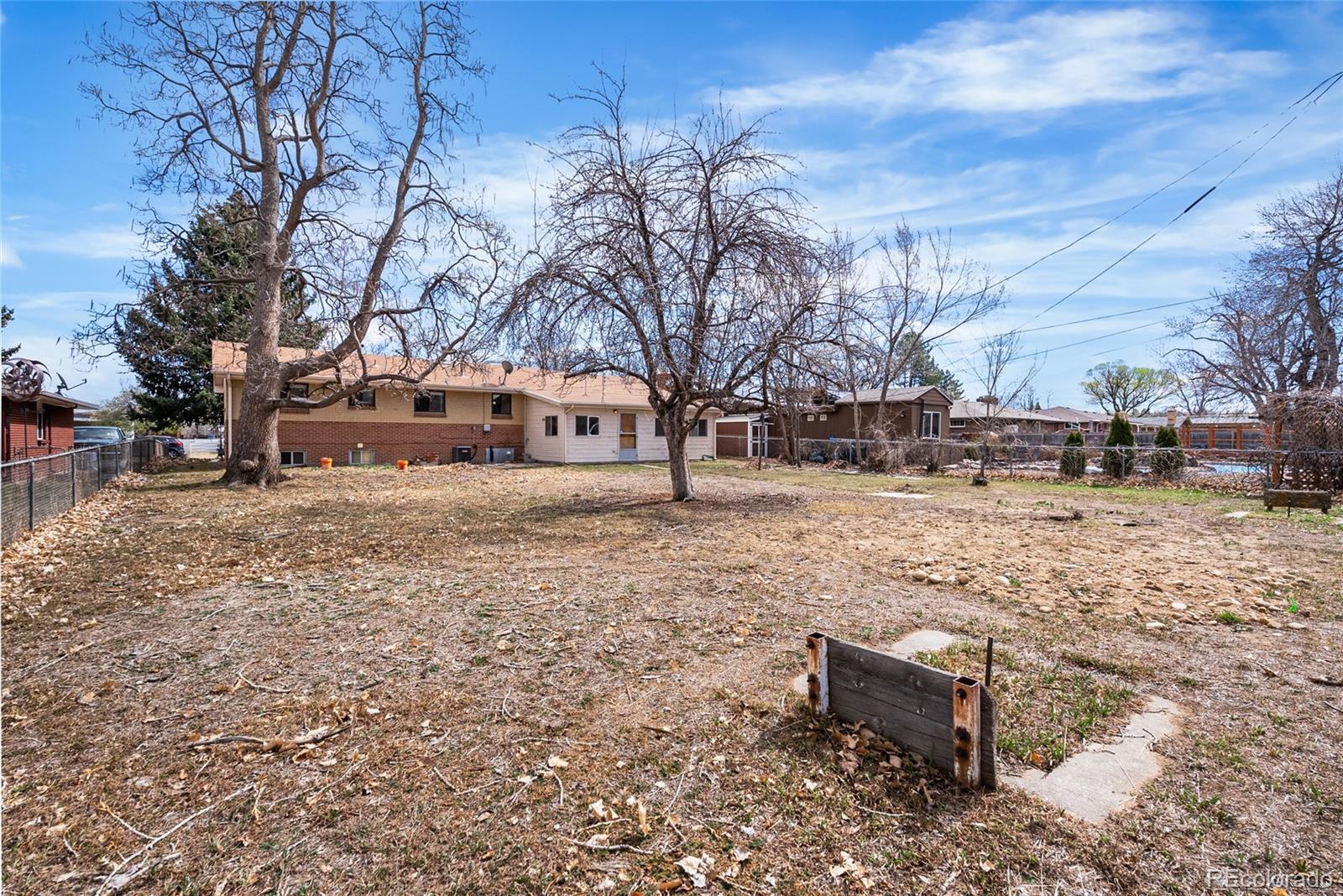 4585 Garland Street Wheat Ridge, CO 80033 - Photo 28 of 35 a backyard of a house with large trees and outdoor seating