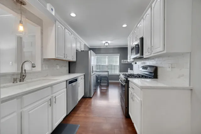 a kitchen with stainless steel appliances granite countertop a sink stove and cabinets