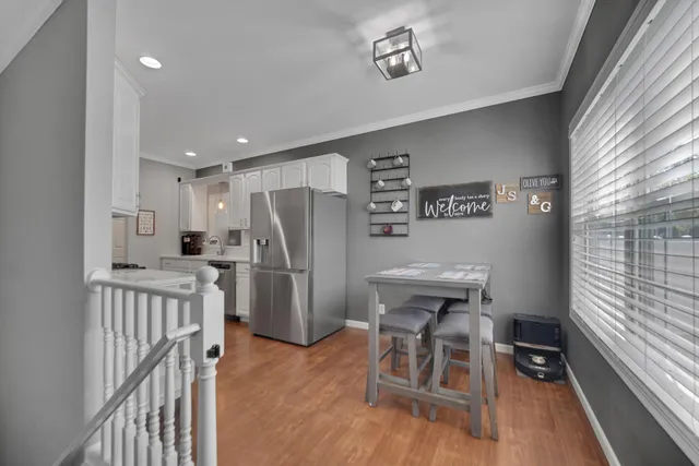 a view of a kitchen with refrigerator and wooden floor