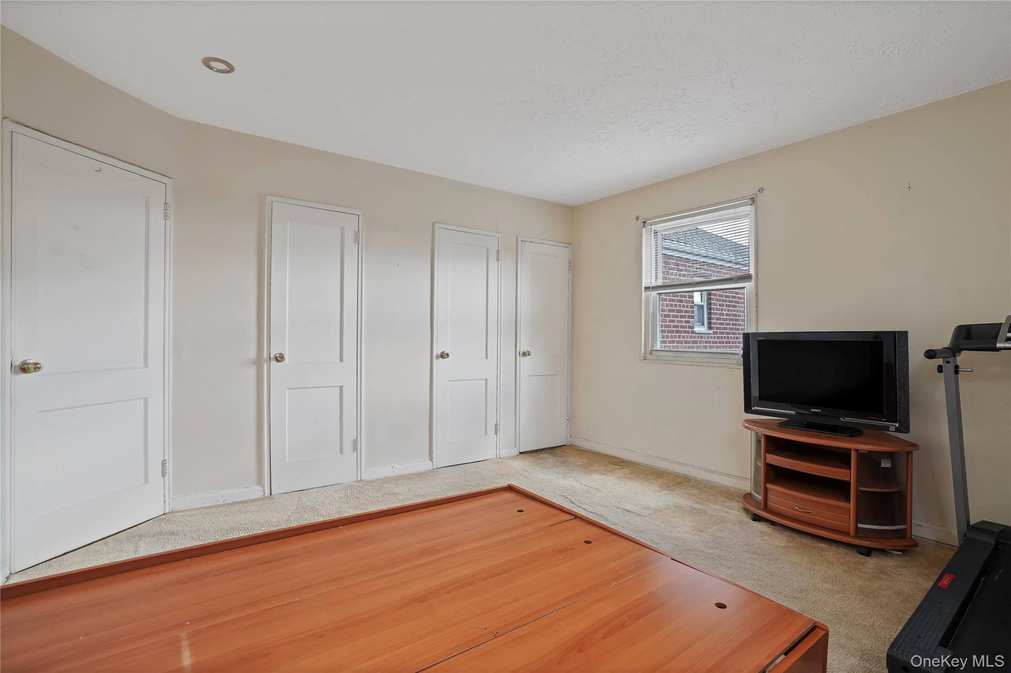 155-27 89th Street, Unit 27 Queens, NY 11414 - Photo 17 of 26 a view of room with wooden floor and flat screen tv