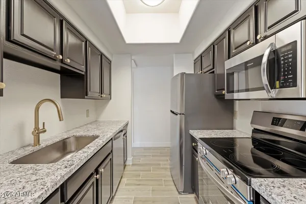a kitchen with stainless steel appliances granite countertop a sink stove and cabinets