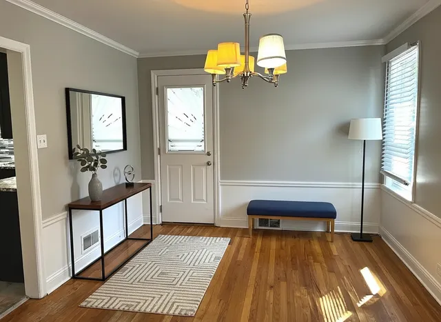 a view of a bedroom with wooden floor and furniture