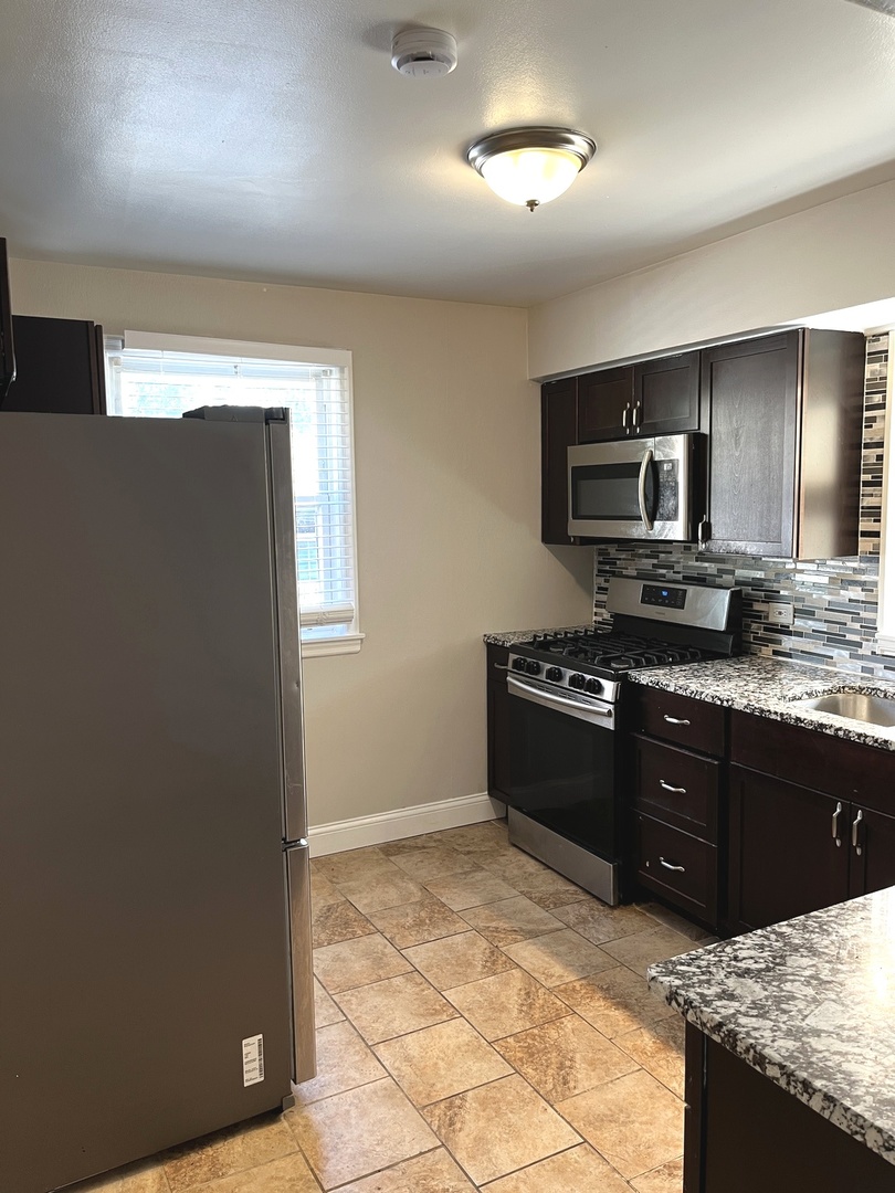 17107 Longfellow Avenue Hazel Crest, IL 60429 - Photo 15 of 21 a kitchen with granite countertop a refrigerator and a stove top oven