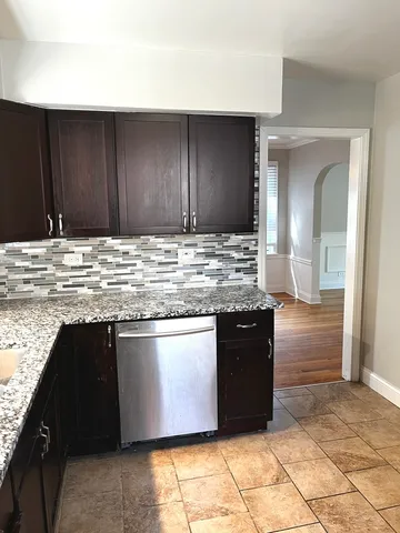 a kitchen with granite countertop a stove and cabinets