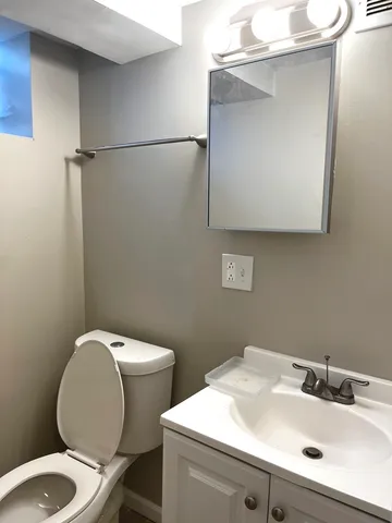 a bathroom with a toilet sink and mirror