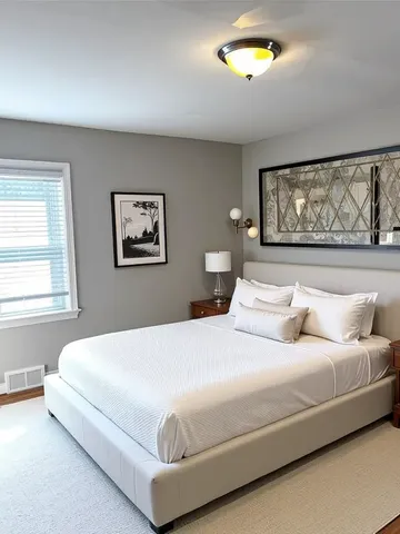 a bedroom with a bed and painting on the wall