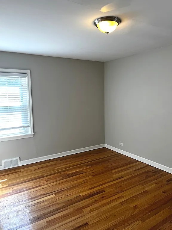 17107 Longfellow Avenue Hazel Crest, IL 60429 - Photo 7 of 21 a view of an empty room with window and wooden floor