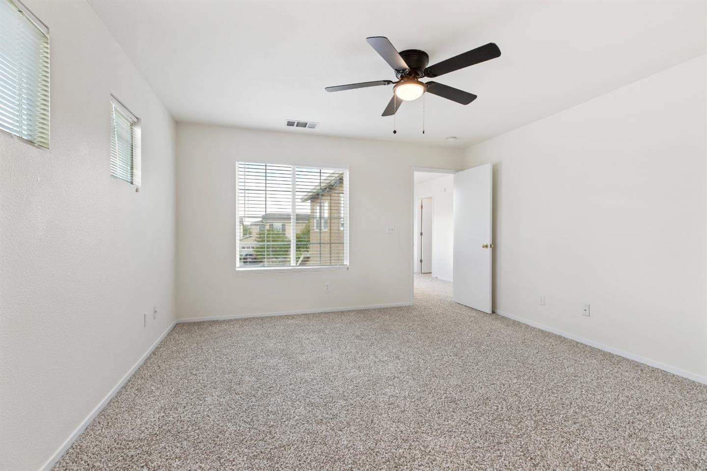 4347 Mathias Way Merced, CA 95348 - Photo 12 of 20 an empty room with ceiling fan and windows