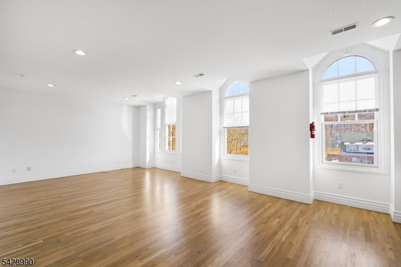 13 Main Street, Unit 3 Sparta, NJ 07871 - Photo 3 of 9 an empty room with wooden floor and windows