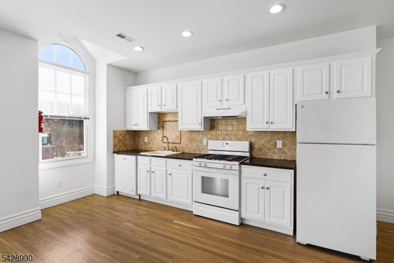 13 Main Street, Unit 3 Sparta, NJ 07871 - Photo 4 of 9 a kitchen with granite countertop white cabinets and white appliances