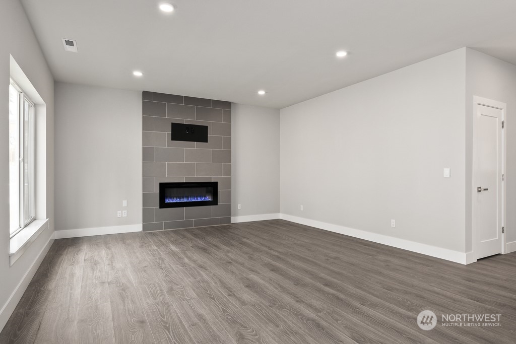 2014 228th Place Southwest, Unit EP 48 Bothell, WA 98021 - Photo 10 of 19 a view of an empty room with wooden floor fireplace and a window
