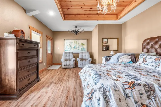 a bedroom with a bed wooden floor and window