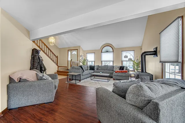 a living room with furniture and a large mirror next to a window