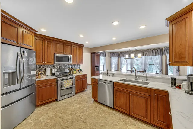 a kitchen with stainless steel appliances granite countertop sink stove microwave and refrigerator