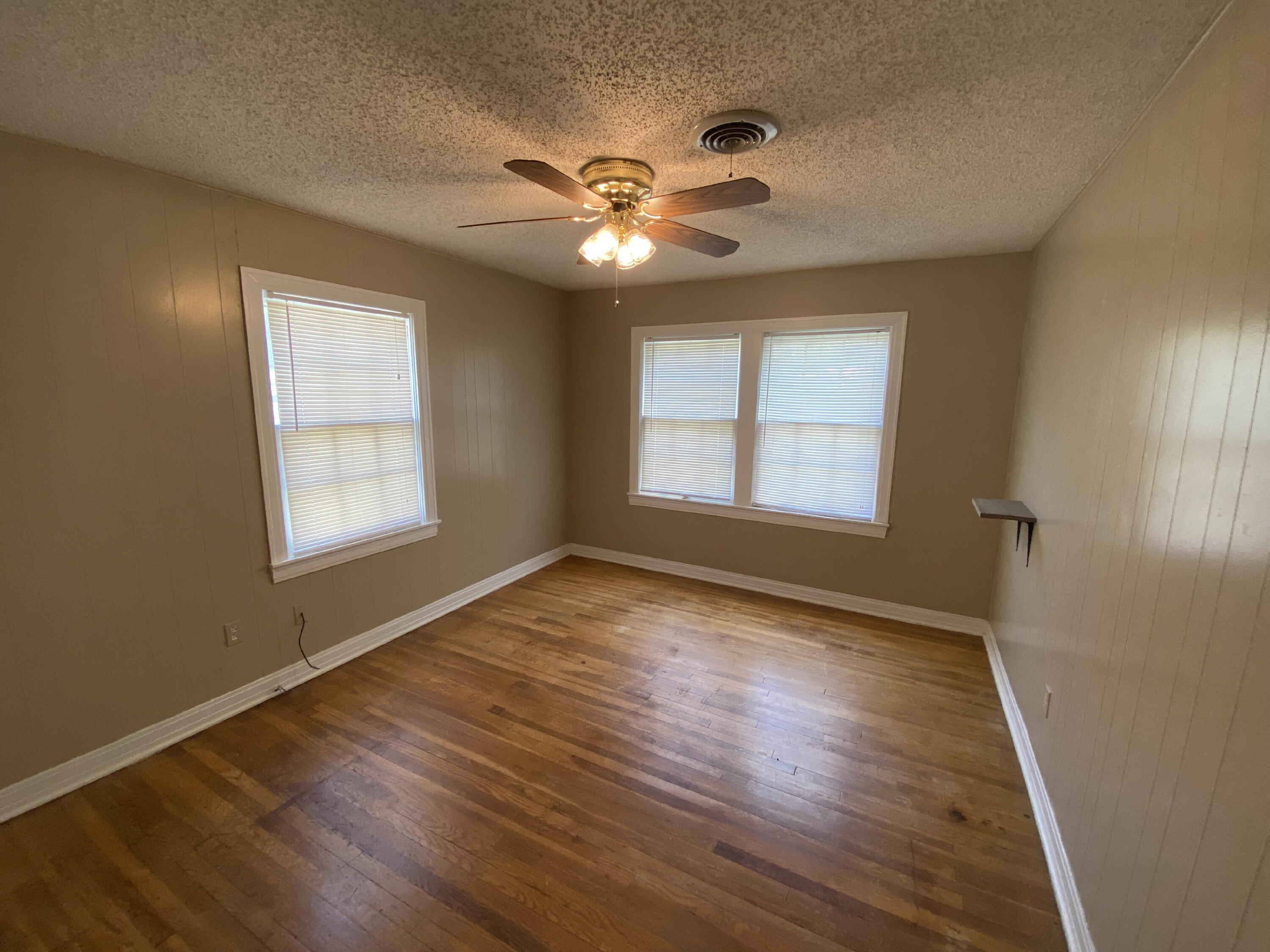 2520 27th Street, Unit FRONT Lubbock, TX 79410 - Photo 8 of 17 a view of an empty room with wooden floor and a window