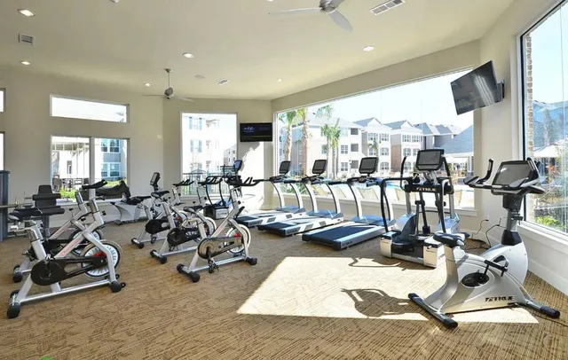 a living room with lots of furniture and gym equipment